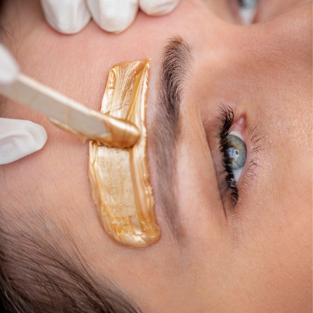 Wax being applied around an eyebrow