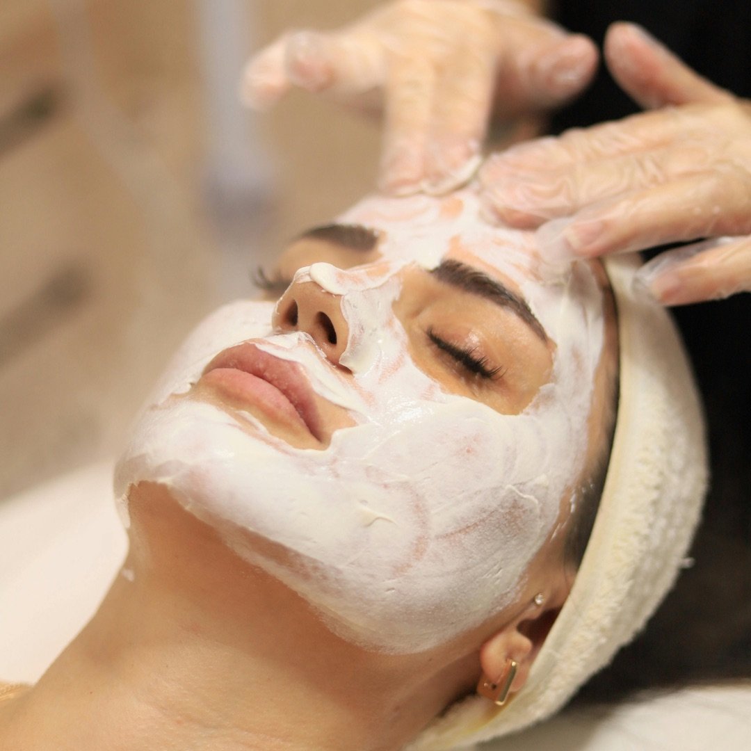 Face mask being massaged during a facial treatment