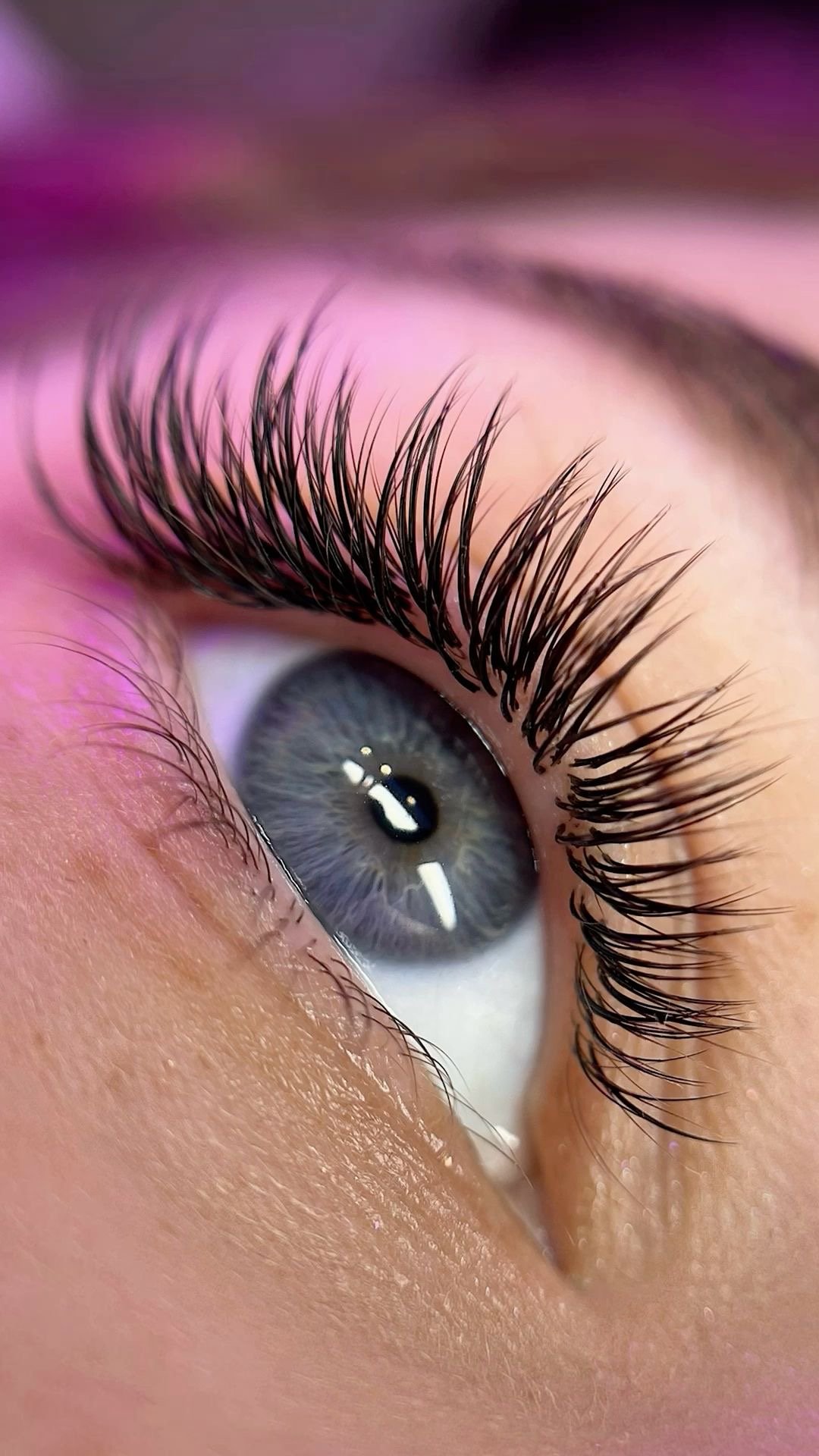 Close-up of a blue eye with curled lash extensions